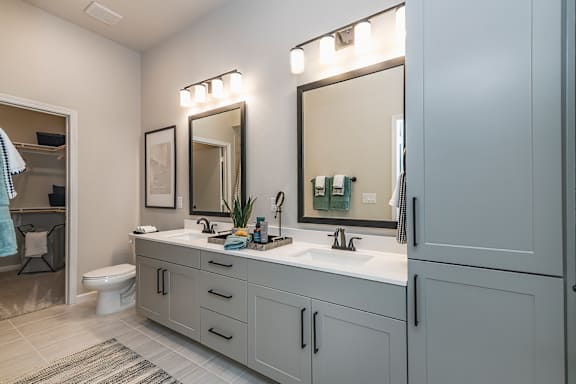 A bathroom with a white toilet and a sink with a mirror above it.