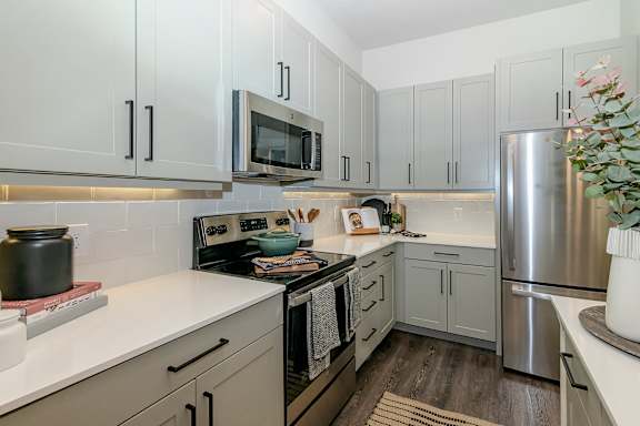 A kitchen with a stove top oven and a refrigerator.