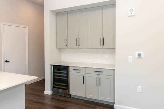 A kitchen with white cabinets and a white countertop.
