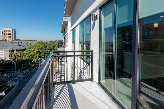 A balcony with glass doors and a metal railing.