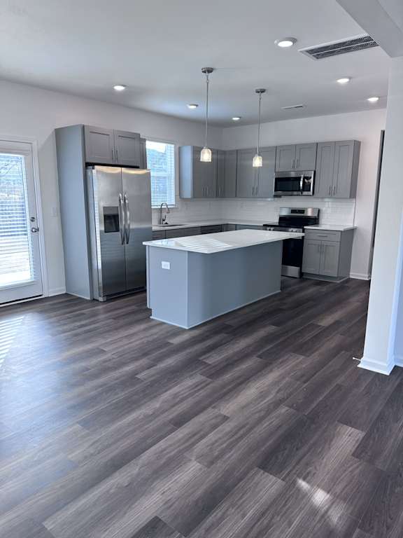 A kitchen with a large island and stainless steel appliances.