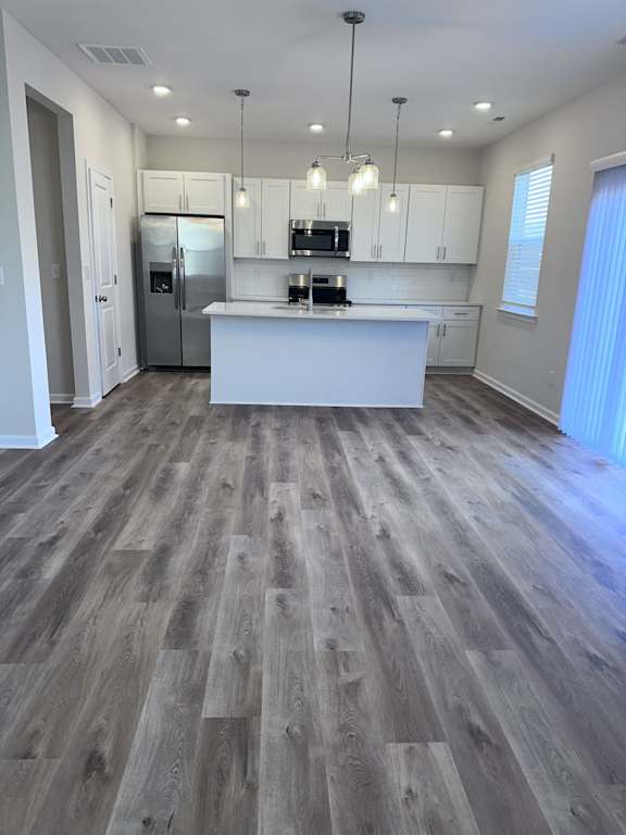 A kitchen with a white counter and a refrigerator.