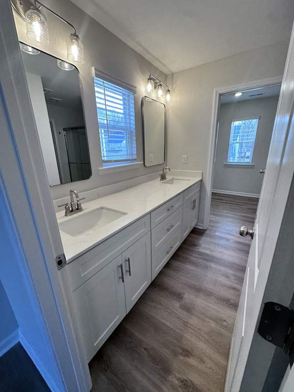 A bathroom with a sink, mirror, and lighting fixtures.