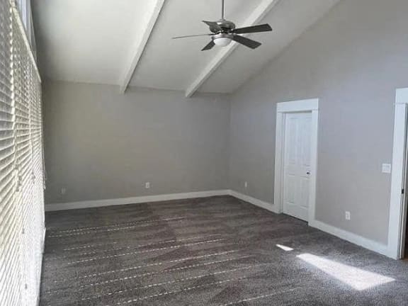 an empty room with a ceiling fan and a white door