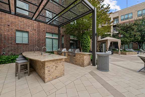 A patio with a table and chairs is surrounded by a brick building.