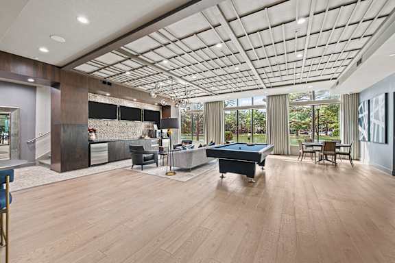 A spacious room with a pool table and a bar area.