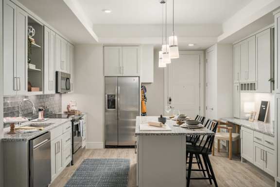 A modern kitchen with a large island and stainless steel appliances.