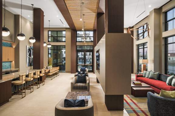 A modern living room with a long couch and a bar area.
