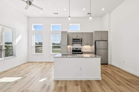 A modern kitchen with a large island and stainless steel appliances.