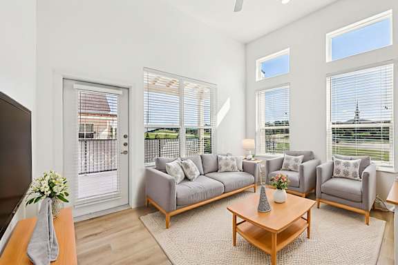 A living room with a grey couch and a wooden coffee table.