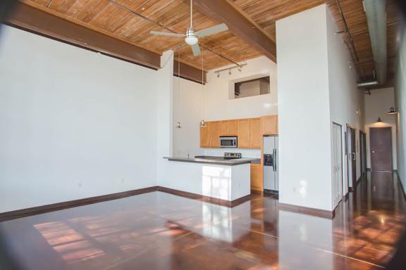 A kitchen with wooden floors and a ceiling fan.