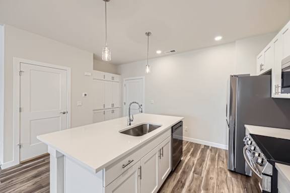 A modern kitchen with a white countertop and stainless steel appliances.