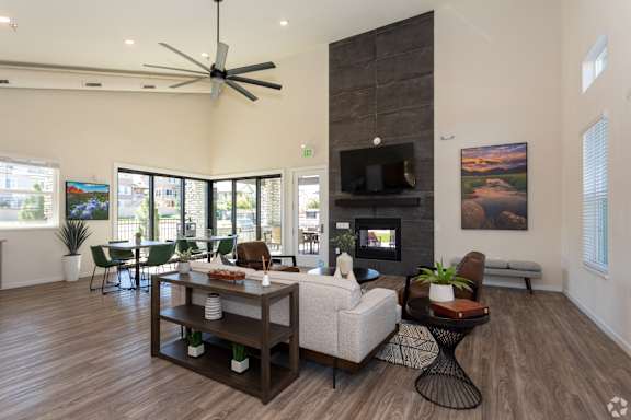 A modern living room with a fireplace and a ceiling fan.