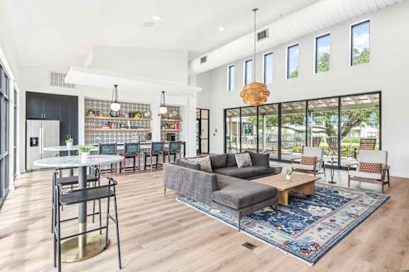 A modern living room with a grey couch and a round table.