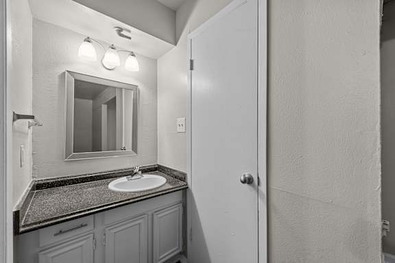 A bathroom with a sink and mirror.