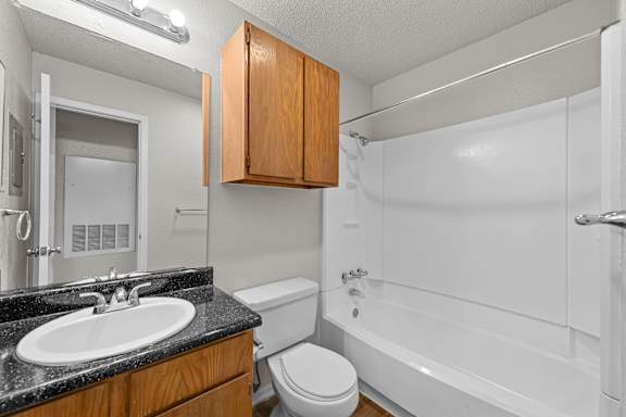 A bathroom with a sink, toilet, and bathtub.