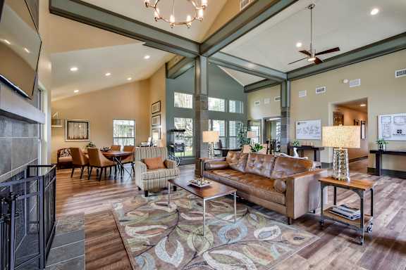 A living room with a brown couch and a rug.