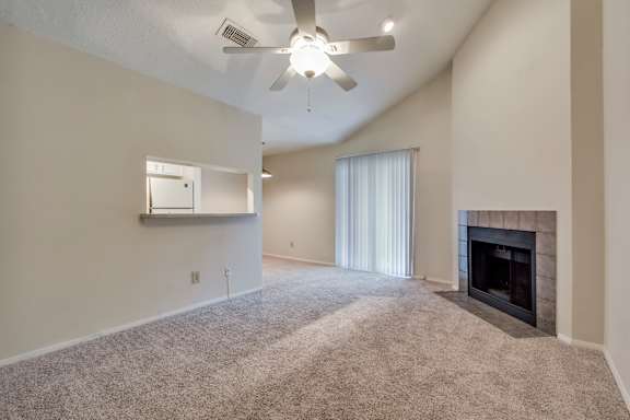 A living room with a fireplace and a ceiling fan.
