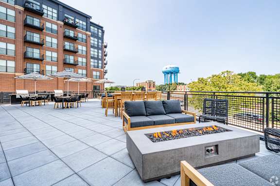 A patio with a fire pit and seating area.