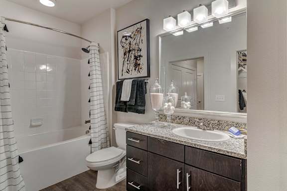 A bathroom with a white toilet, a white sink, and a white shower curtain.