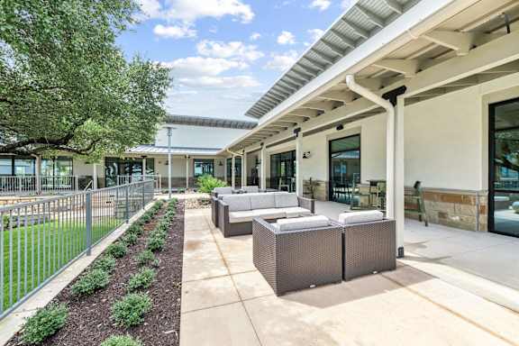 A patio area with a white building in the background.