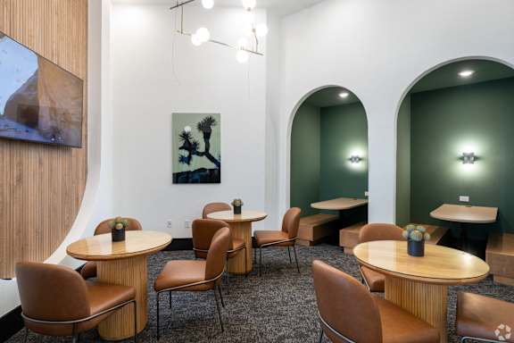 A room with tables and chairs and a painting on the wall.