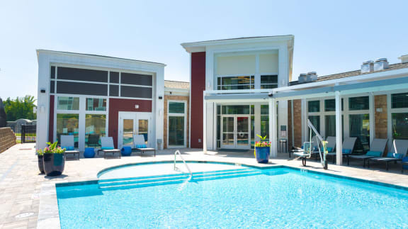 a swimming pool in front of a house with a pool