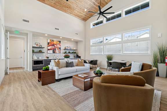 A living room with a white couch, brown armchair, and a coffee table.