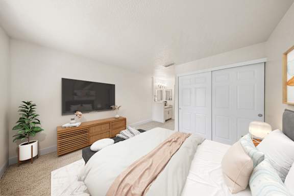 A bedroom with a bed, a TV, and a plant.