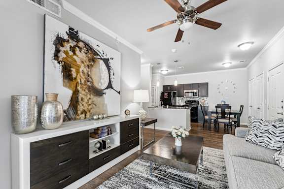 A modern living room with a large abstract painting on the wall.