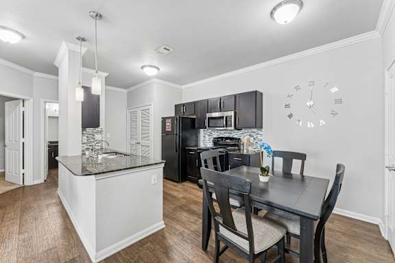 A kitchen with a black table and chairs.