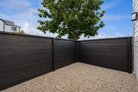 A black fence with a tree in the background.