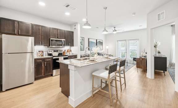 A kitchen with a white island and wooden floors.