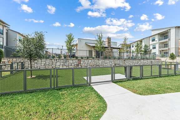 A modern building with a stone wall and a metal fence in front of it.