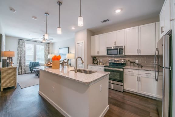 a kitchen with white cabinets and a large island