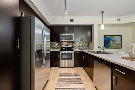 a modern kitchen with stainless steel appliances and black cabinets