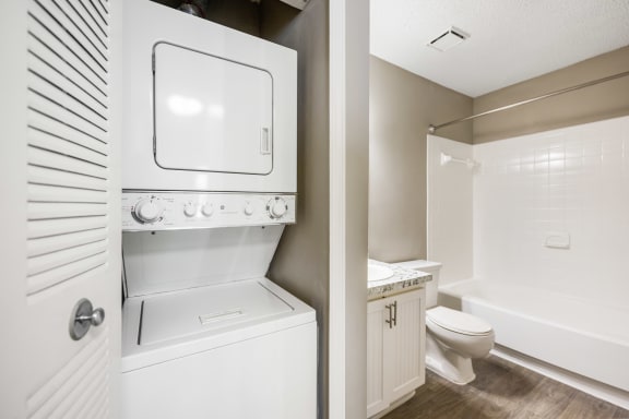 a renovated bathroom with a washer and dryer and a toilet