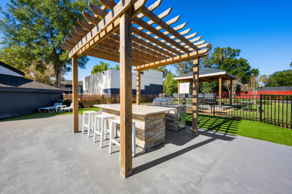 a patio with a picnic table and a grill