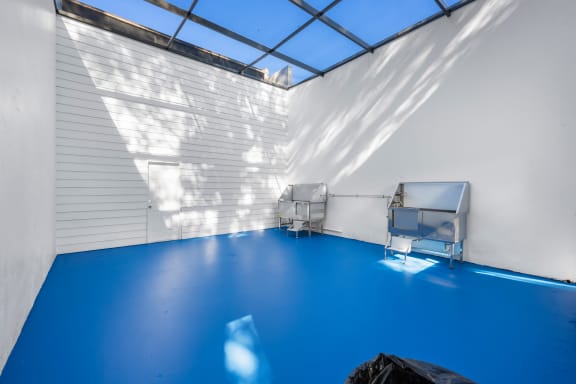 a white room with a blue floor and two refrigerators