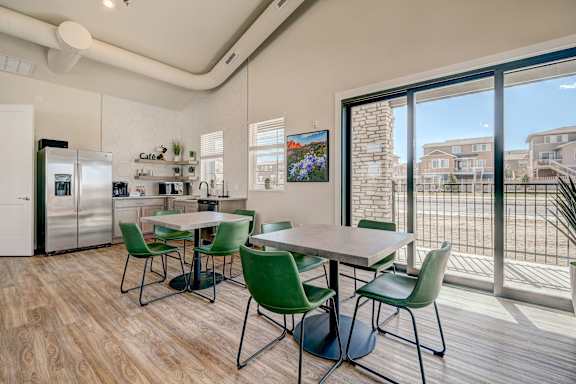 A kitchen with a dining table and chairs.