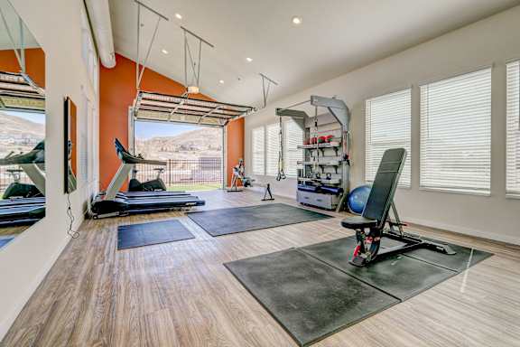 A room with a pilates reformer and a yoga mat.