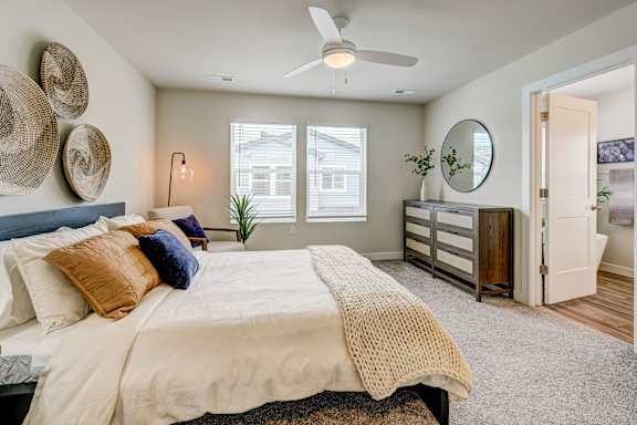 A bedroom with a large bed and a ceiling fan.