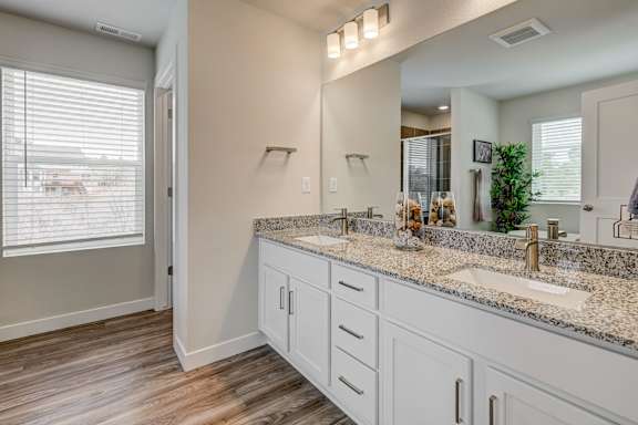 A bathroom with a large mirror and two sinks.