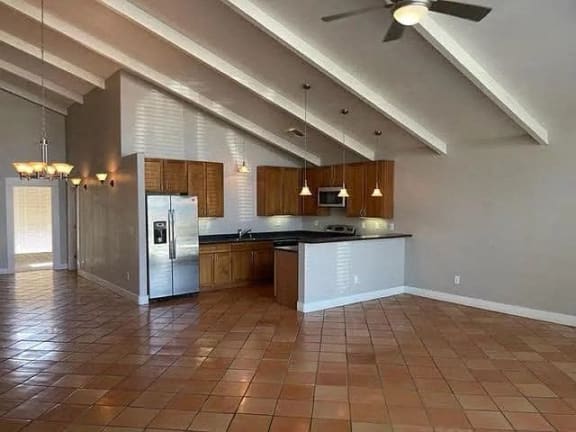 an empty kitchen with a stainless steel refrigerator