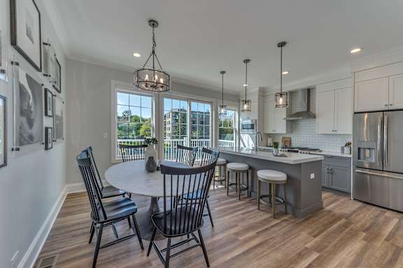 A modern kitchen with a dining table and chairs.