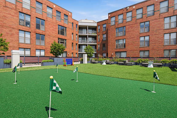 A green lawn in front of a red brick building.