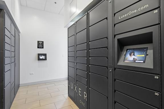 A row of black lockers with the word "LUXER" on the bottom of each one.