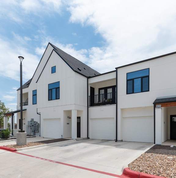 A modern two-story house with a white exterior and black accents.