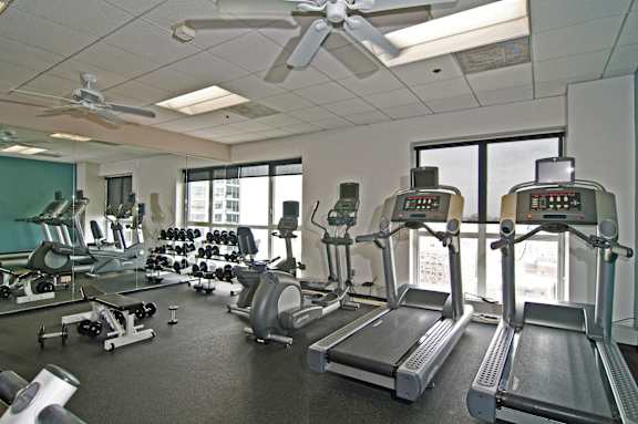 A gym with treadmills, weights, and exercise equipment.