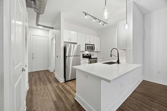 A kitchen with white cabinets and a white countertop.